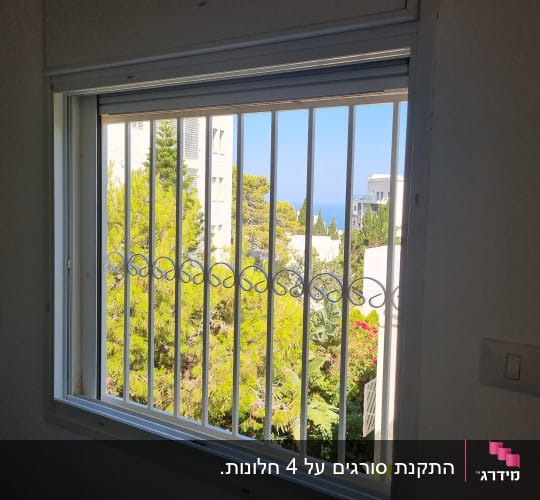 סורגים ישרים ממתכת בצבע לבן מותקנים בחלון דירה